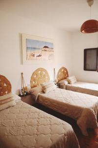 a bedroom with two beds and a tv on the wall at Casa Olga in Caleta de Sebo