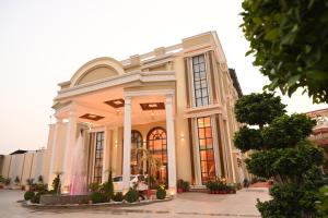 een groot wit gebouw met een groot raam bij Hotel Krinoscco in Ayodhya