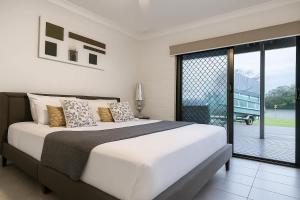 ein Schlafzimmer mit einem großen Bett und einer Glasschiebetür in der Unterkunft Waterfront Coomera Escape in Gold Coast