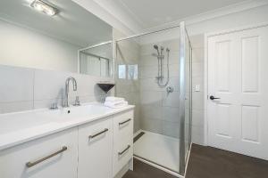 ein weißes Badezimmer mit Dusche und Waschbecken in der Unterkunft Waterfront Coomera Escape in Gold Coast