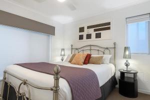 ein weißes Schlafzimmer mit einem großen Bett und einem Fenster in der Unterkunft Waterfront Coomera Escape in Gold Coast + 51 Fotos