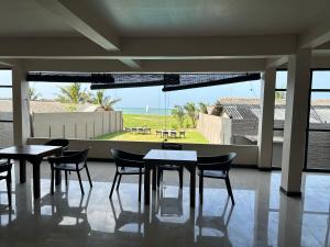 a dining room with tables and chairs and a view of the ocean at Trident Sea Hotel in Negombo