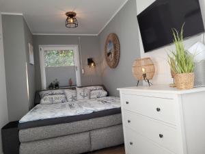 a small bedroom with a bed and a white dresser at Sonneninsel Wiek mit eigener Sauna und Fahrradgarage inkl Wäschepaket in Wiek auf Rügen