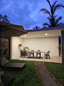 a patio with a table and chairs and an umbrella at VODA Hotel in Galle