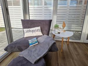 a chair with a pillow and a table on a porch at Sonneninsel Wiek mit eigener Sauna und Fahrradgarage inkl Wäschepaket in Wiek auf Rügen