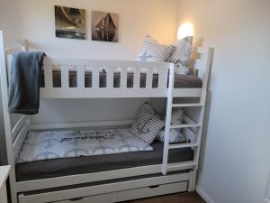 a bunk bed in a room with pillows on it at Sonneninsel Wiek mit eigener Sauna und Fahrradgarage inkl Wäschepaket in Wiek auf Rügen +34 photos
