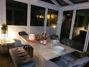 a dining room with a table with plates and wine bottles at Sonneninsel Wiek mit eigener Sauna und Fahrradgarage inkl Wäschepaket in Wiek auf Rügen