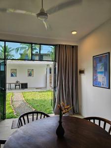 a dining room with a table and a large window at VODA Hotel in Galle +215 photos