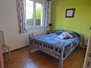 een slaapkamer met een bed en een raam bij BRUYERE D'ANDAINE in Bagnoles de l'Orne