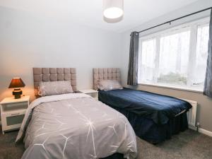 a bedroom with two beds and a window at Green Bank in Dymchurch