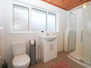 a bathroom with a toilet and a sink and a shower at Green Bank in Dymchurch +13 photos