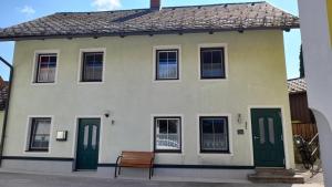 a house with green doors and a bench in front of it at Haus Lüftleck in Lunz am See