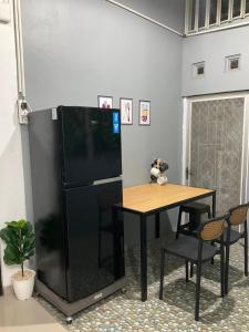 een zwarte koelkast en een tafel in een kamer bij Wening Stay in Srondolwetan +17 foto's