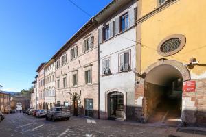 een steegje met auto's naast een gebouw bij GuestHost - La Volta Apartments in Urbino