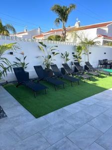 a row of chairs on a lawn next to a wall at Villa Palma Cabo Roig 31a in Orihuela Costa