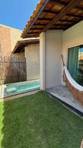 a hammock hanging from the side of a house at Vila Gaheri in São Miguel dos Milagres +11 photos