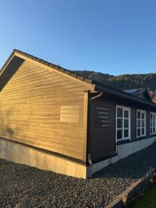 a large wooden building with a sign on the side of it at Siggjo Guesthouse Bømlo and Stord in Mosterhamn +9 photos
