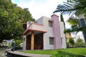 a pink and white house with a palm tree at Arpan Villa in Aurangabad +5 photos
