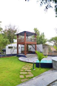a building with a deck in the middle of a yard at Arpan Villa in Aurangabad