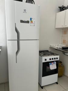 un réfrigérateur blanc dans une cuisine avec une cuisinière dans l'établissement Linhares beach, à Cabedelo 28 autres photos
