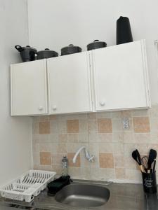 un comptoir de cuisine avec des armoires blanches et un évier dans l'établissement Linhares beach, à Cabedelo