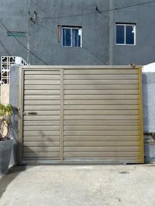 une porte de garage en bois devant un bâtiment dans l'établissement Linhares beach, à Cabedelo