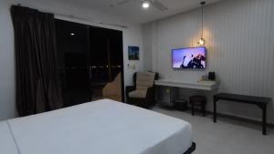 een slaapkamer met een bed, een bureau en een tv bij Samui Pier Beach Front & Resort in Bangrak Beach