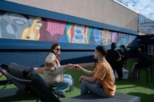 Een man en een vrouw zitten voor een muurschildering. bij Ideal Youth Hostel in Barcelona