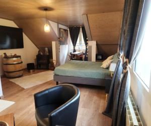 a bedroom with a bed and a chair in a room at Chambre d'hôte de la Source Bleue in Cusance
