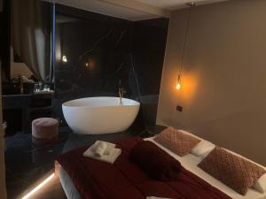 a bathroom with a tub and a bed with towels at CBH Sicitaly group in Aci Castello