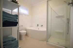 e bagno con doccia, vasca e servizi igienici. di Rosebud Comfort Retreat a Rosebud Altre 16 foto