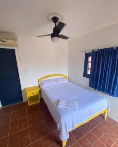 una camera da letto con un letto e un ventilatore a soffitto di Hotel Pueblo Alegre a Huamboya