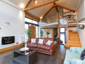 a living room with a couch and a staircase at The Lodge Lodge Farm in Bedford