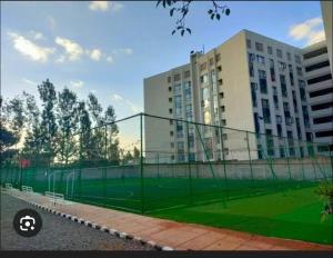 a tennis court in front of a large building at The cozy nook - Thindigua in Kiambu
