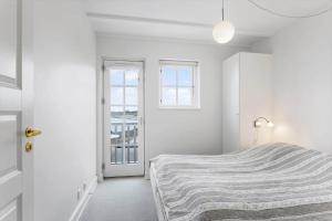 a white bedroom with a bed and a window at LL264-Bagenkop-Faergevej-9-1-th in Bagenkop
