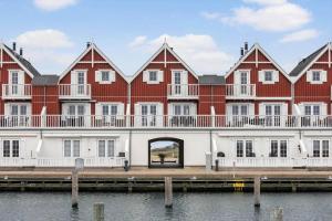 a large red and white building next to the water at LL264-Bagenkop-Faergevej-9-1-th in Bagenkop