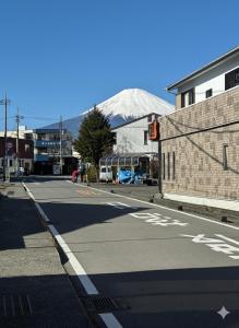 an empty street with a snow covered mountain in the background at 富士Base御殿場 Station-Side Hideout in Gotemba
