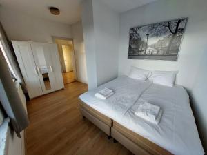 een slaapkamer met een wit bed met een schilderij aan de muur bij Authentic stay in Alkmaar in Alkmaar