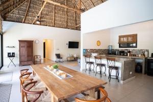 a dining room and kitchen with a wooden table and chairs at Cala los Mangos in Tamanique