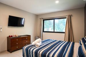 a bedroom with a bed and a flat screen tv at Cala los Mangos in Tamanique +24 photos