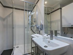 ein weißes Bad mit einem Waschbecken und einer Dusche in der Unterkunft Gorgeous Prague Rooms in Prag
