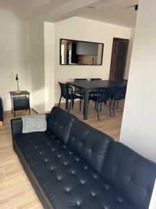 a living room with a black couch and a table at Villa Palma Cabo Roig 31a in Orihuela Costa