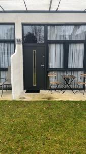 eine schwarze Haustür mit einem Tisch und Stühlen in der Unterkunft Baadenbergerstay B in Köln