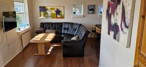 un soggiorno con un divano in pelle e un tavolo di Fihermans House Joanna2 a Hirtshals