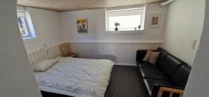 una piccola camera da letto con un letto e un divano di Fihermans House Joanna2 a Hirtshals