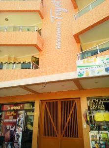 アビジャンにあるRésidence Toyotaの側面に看板がある建物