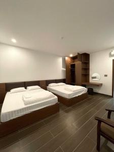 a bedroom with two beds and a desk at Phú Thọ Hotel in Chú Mật