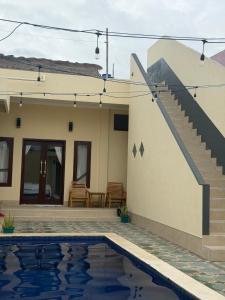 a house with a swimming pool in front of a house at Amlana villa in Gili Trawangan