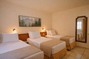 a hotel room with two beds and a mirror at Aguas do Iguaçu Hotel Centro in Foz do Iguaçu +21 photos