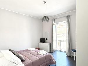 a white bedroom with a bed and a window at Luxury Apartment in Crotone